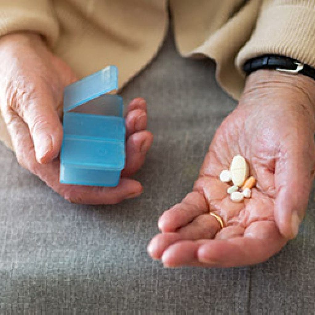 elderly man taking medications