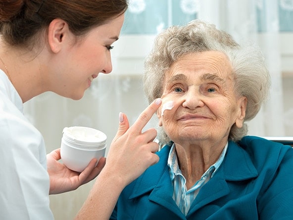 elderly woman being pampered by nurse