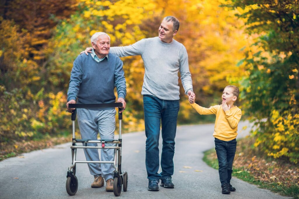 elderly man with walker and his son and grandson